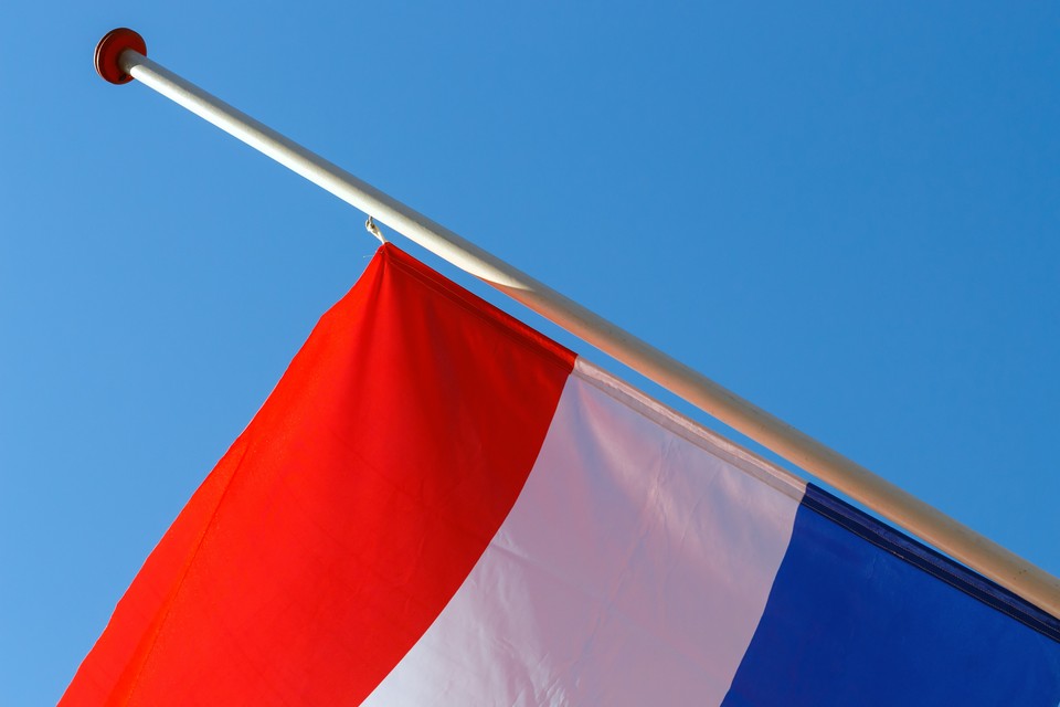 De Nederlandse vlag halfstok. 