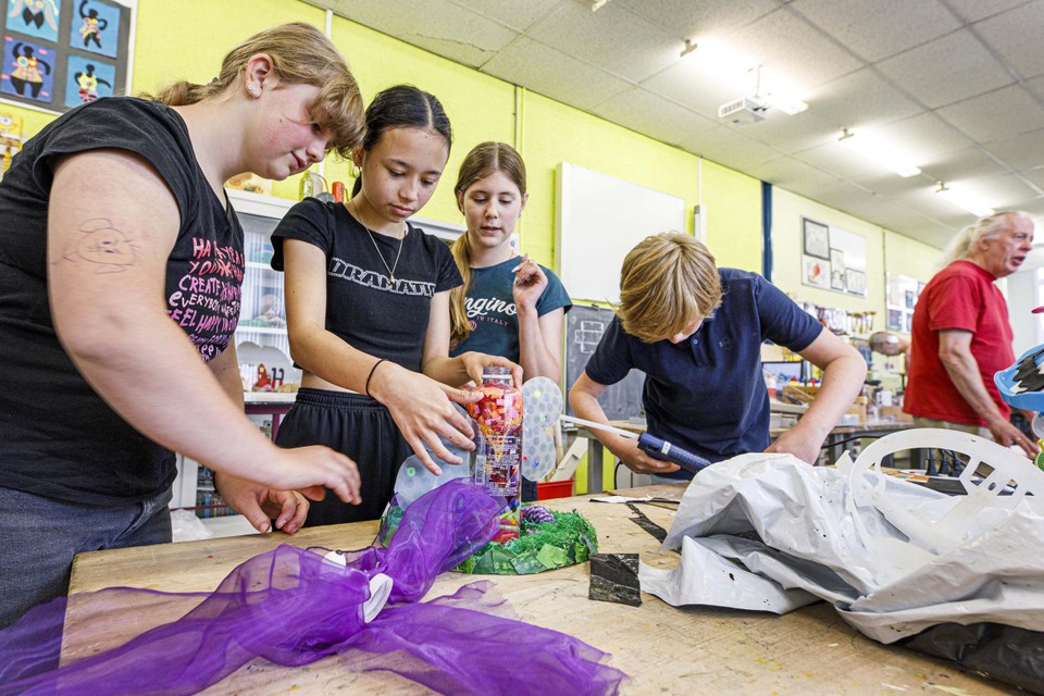 Shana, Demi en Alycia werken aan hun vogelvlinder. Op de achtergrond kunstenaar Michiel Romme. 