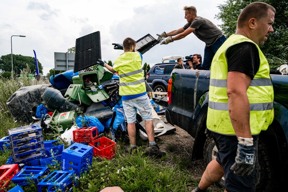 Vrijwilligers zijn bezig met het opruimen van afval langs de Maas. 