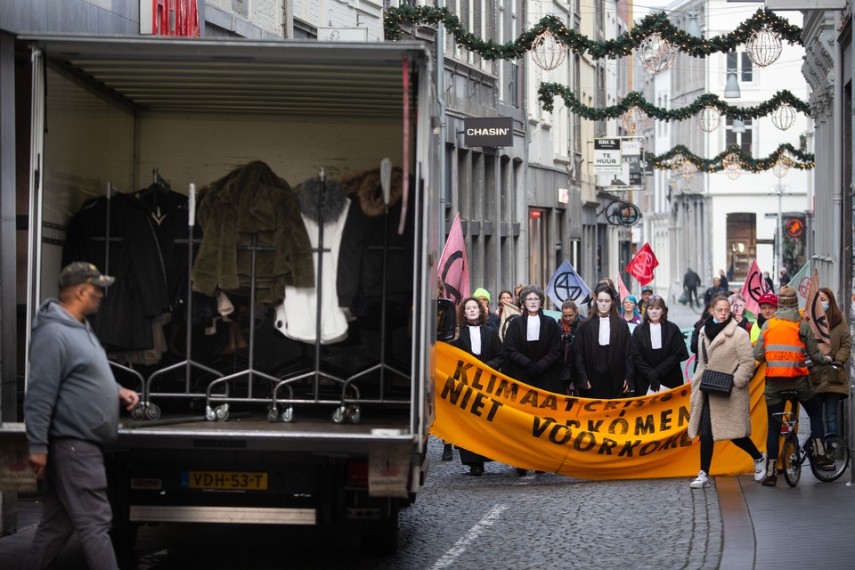 Activisten van Extinction Rebellion lopen in een stoet van de Markt naar de rechtbank in Maastricht.  