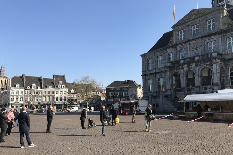 Iedereen keurig in de rij voor de weinige kramen op de woensdagmarkt van Maastricht. 