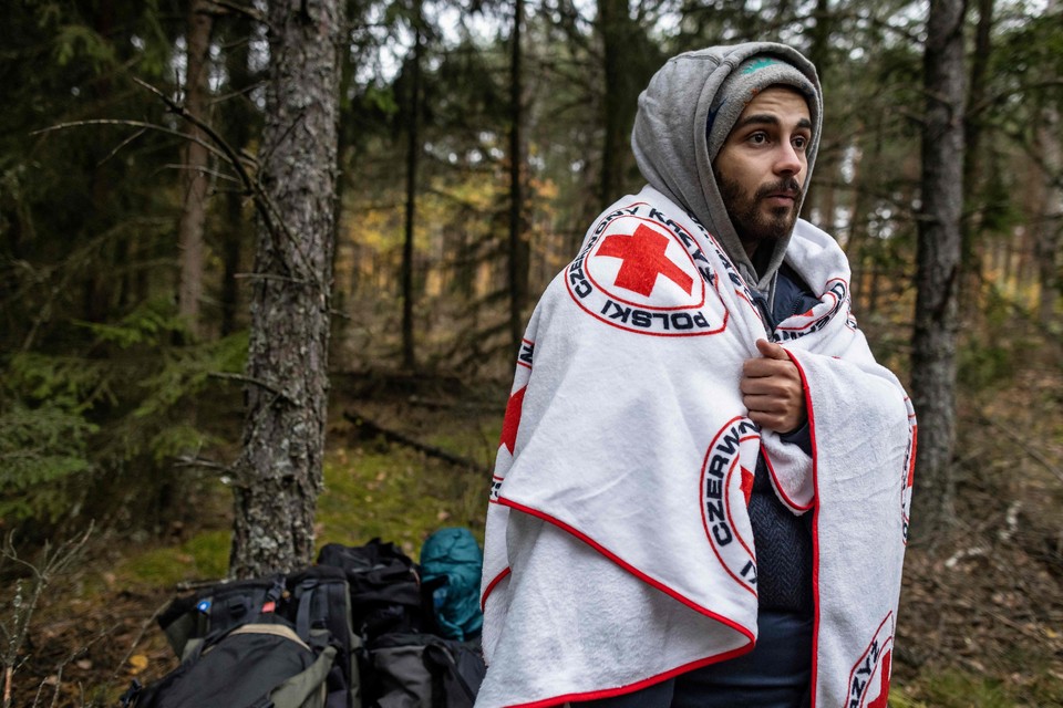 Een Libanese migrant in het grensgebied tussen Wit-Rusland en Polen met een deken van het Rode Kruis.