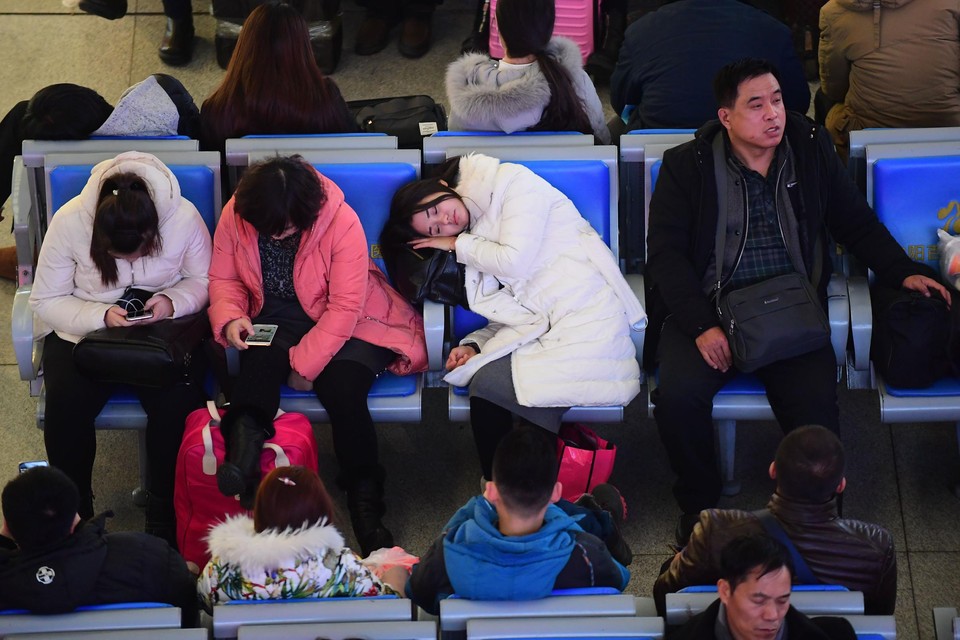 Reizigers wachten in een station in Bejing.