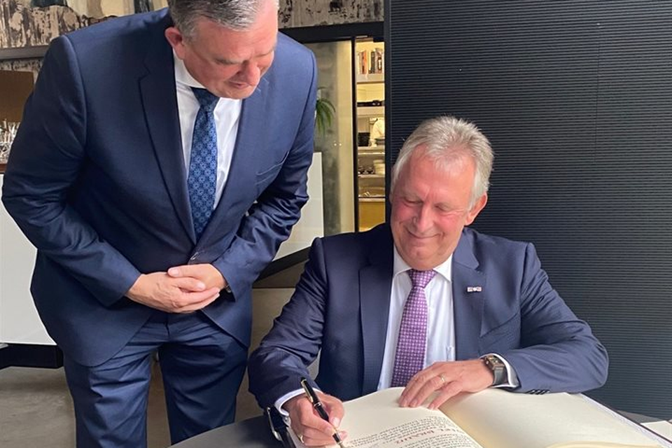 Giel Braun tekent in het bijzijn van gouverneur Emile Roemer het ereboek in het provinciehuis.  