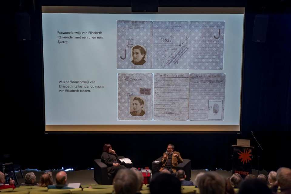 Samuel de Leeuw vertelde zaterdag in Schunck het verhaal over zijn Limburgse onderduikperiode. Op de achtergrond foto’s van het echte en het vervalste persoonsbewijs van zijn moeder.