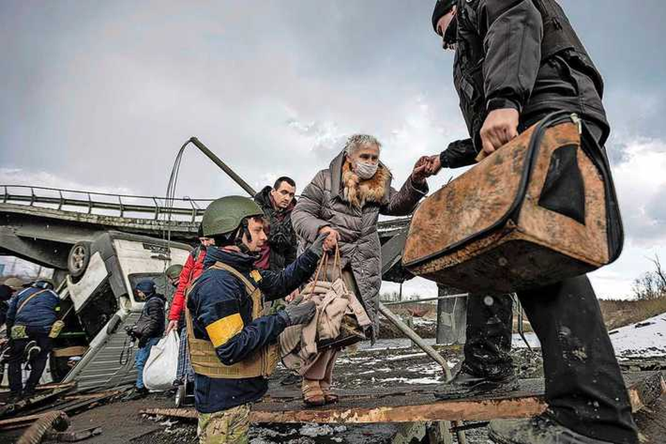 Oekraïners proberen hun weg te vinden over een compleet verwoeste brug in Irpin. 