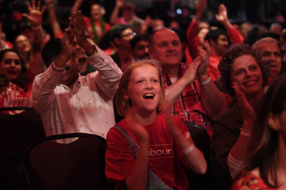Een jonge aanhanger van de Nieuw-Zeelandse Labor Party applaudisseert tijdens de verkiezingsavond op 17 oktober 2020 in Auckland. 