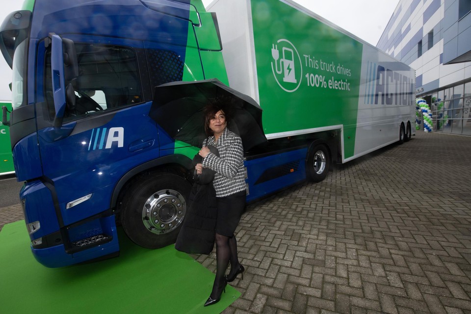 Action-topvrouw Hajir Hajji bij een van de twee 100 procent elektrische trucks die gaan pendelen tussen het distributiecentrum in Echt en de Limburgse Action-filialen.
